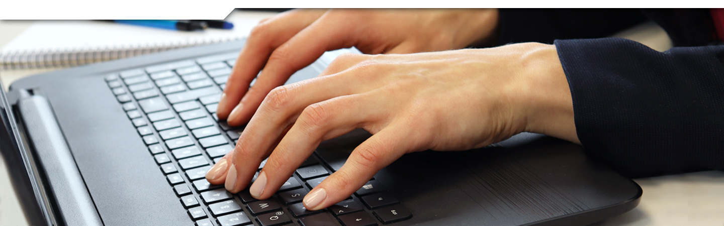 Hände schreiben auf Laptop-Tastatur
